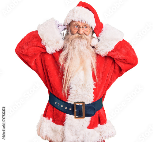 Old senior man with grey hair and long beard wearing traditional santa claus costume smiling pulling ears with fingers, funny gesture. audition problem
