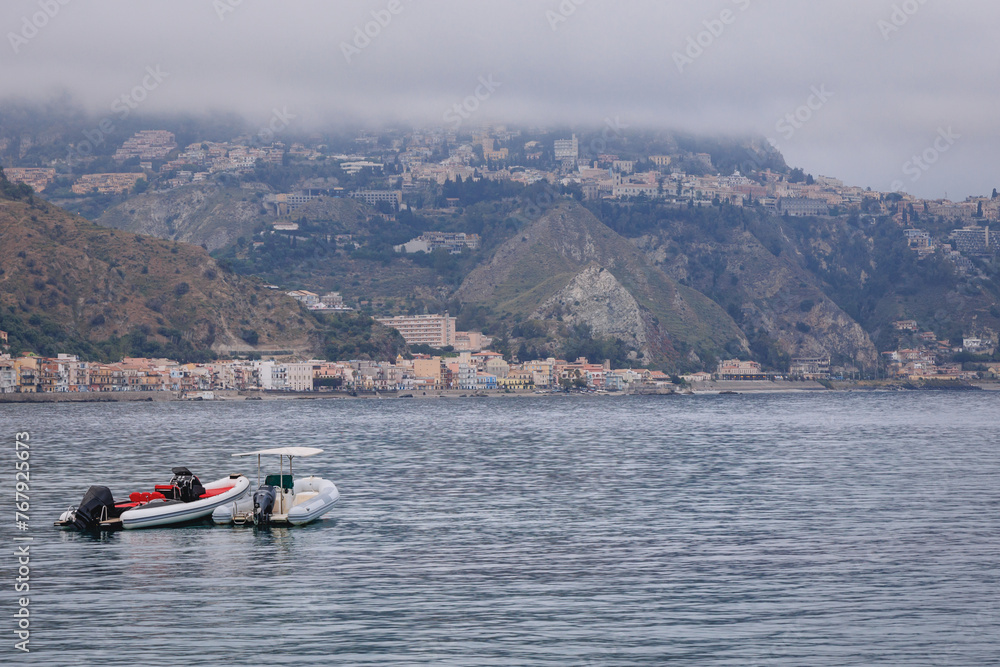 Obraz premium Ionian Sea seen from Giardini Naxos in the Metropolitan City of Messina on the island of Sicily, Italy. View with Villagonia - Taormina city