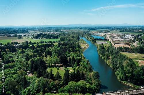 Aerial view of McKenzie River surrounded by lush green on a sunny day © Wirestock