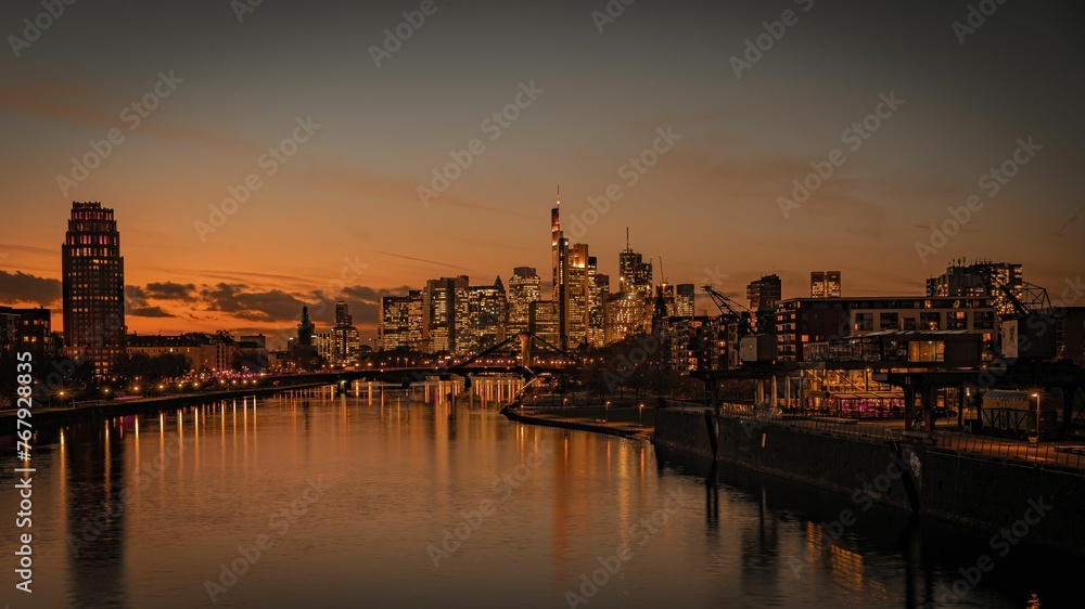 Tranquil river flowing through modern buildings at sunset