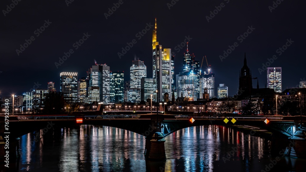 Tranquil river flowing through modern buildings and skyscrapers at night