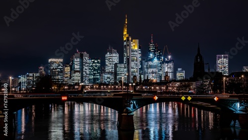 Tranquil river flowing through modern buildings and skyscrapers at night © Wirestock