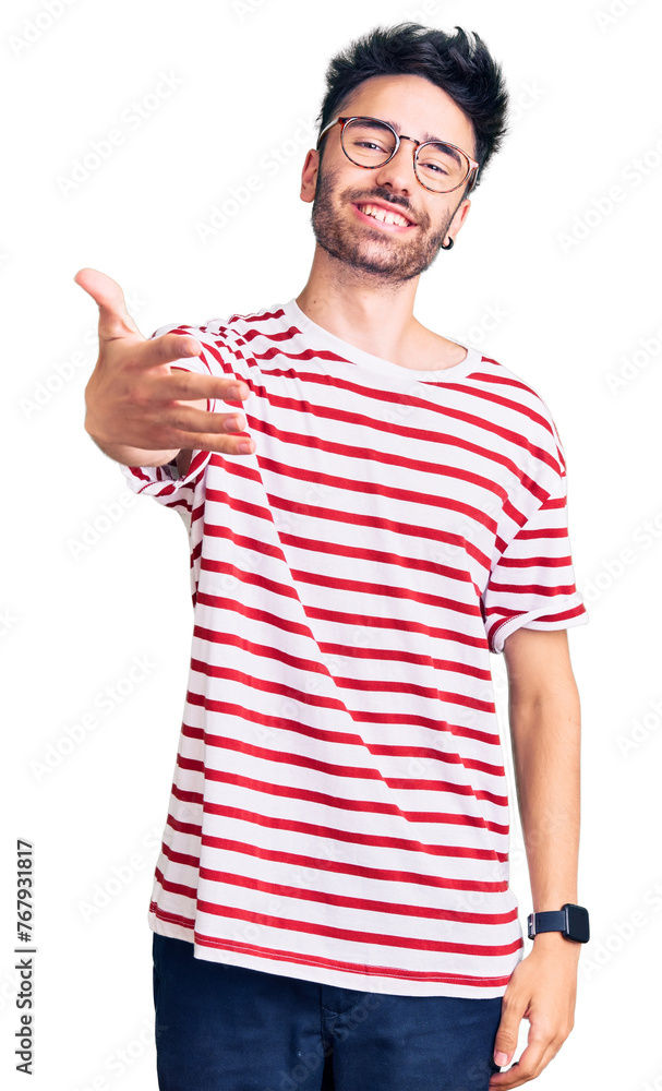 Young hispanic man wearing casual clothes smiling cheerful offering palm hand giving assistance and acceptance. Young hispanic man wearing casual clothes smiling cheerful offering palm hand giving assistance and acceptance.