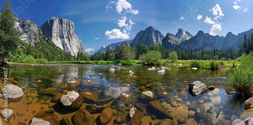 panoramic photo of Yosemite National Park, river and rocks in the foreground, blue sky, mountains in the background, green trees