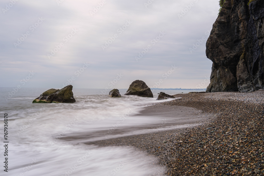 Water waves of the Black Sea crashing on rocks on the stony shore, coast - close up, nobody, no people. Nature, element, landscape