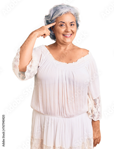 Senior woman with gray hair wearing bohemian style smiling pointing to head with one finger, great idea or thought, good memory