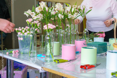 Fotografie A florist is preparing a workplace for a master class for children on assembling bouquets of flowers