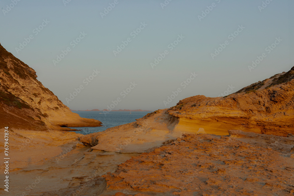 A scenic view of a rock formation landscape going to the ocean