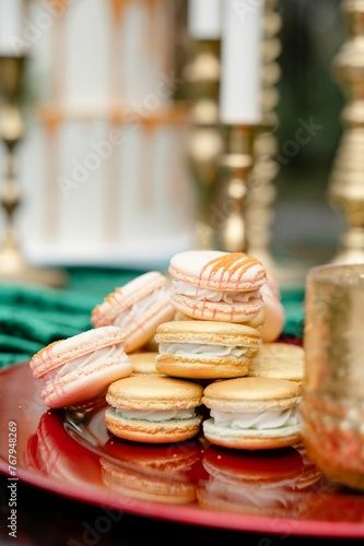 Delicious plate of freshly-baked macarons with candles in the background