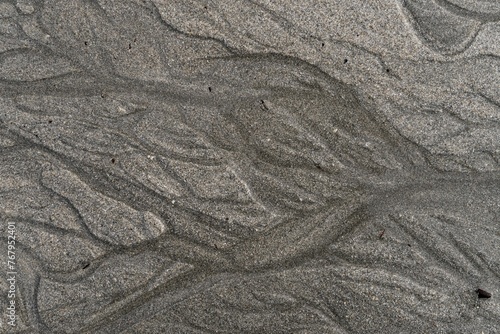 Gray sandy surface with abstract lines.