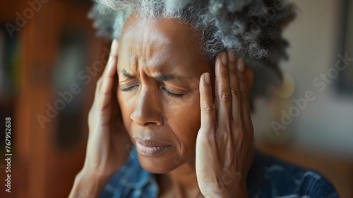 A middle aged woman having a severe headache photo