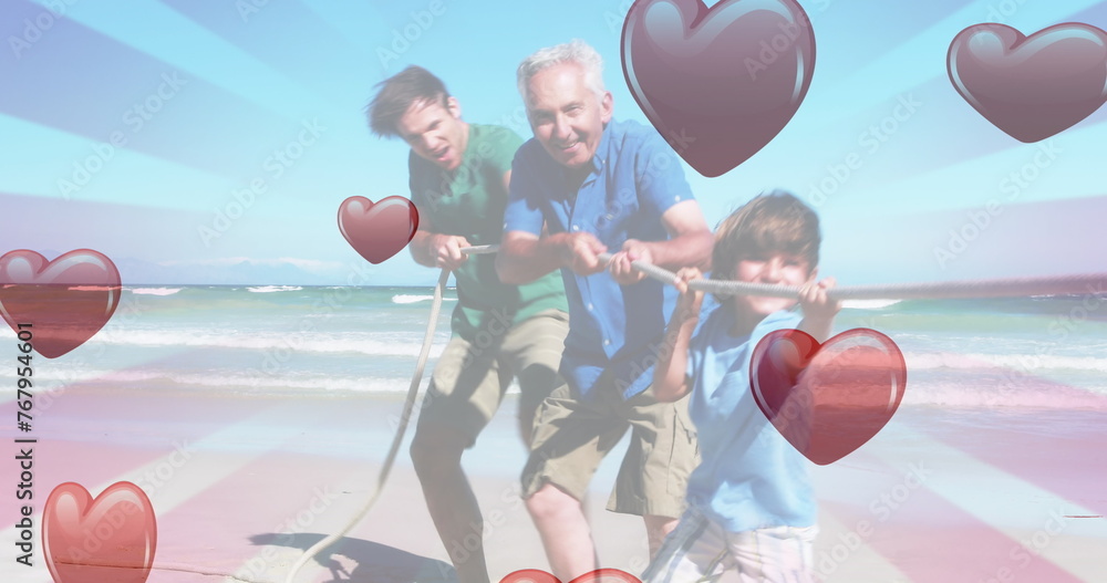 Fototapeta premium Image of hearts falling over caucasian family at beach