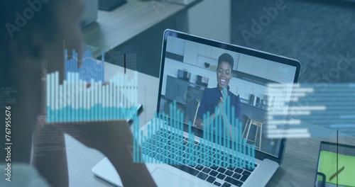 Image of financial data and graphs over african american woman having image call on laptop