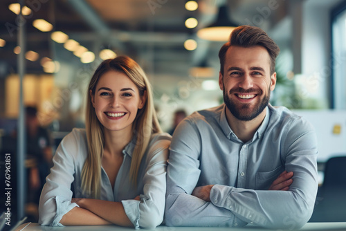 Happy smiling young business people in modern office workplace. Banner background with portrait of two satisfied successful colleagues, team leaders, teammates, business partners and friends at work