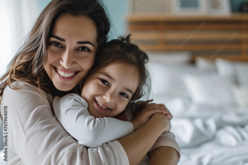 Latin woman and her little daughter hugging in bedroom Latin woman and her little daughter hugging in bedroom