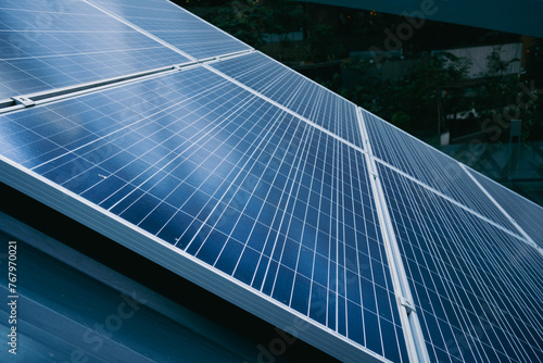 A solar panel is shown in the image  with a blue and silver color scheme. The panel is installed on a roof  and it is a large  multi-panel system