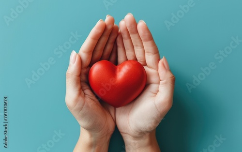 hands hold a red heart on a blue background