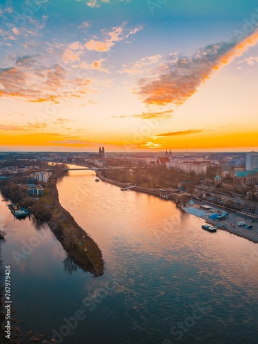 the sunrise over a city with water and buildings in the distance