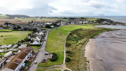 Aerial view of Maidens, Ayrshire, Scotland with a lush green grassy area © Wirestock
