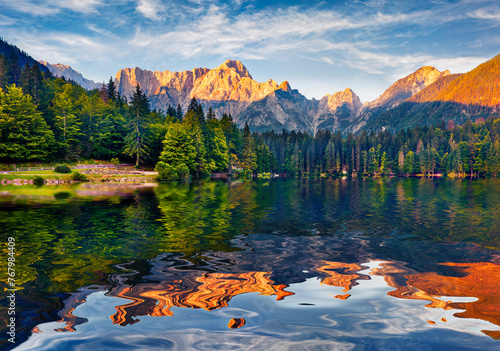 Mangart peak reflected in the calm waters of Fusine lake. Stunning summer view of Julian Alps, Province of Udine, Italy, Europe. Beauty of nature concept background.