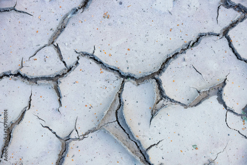 Large cracks in the ground near dry bodies of water in the dry season.