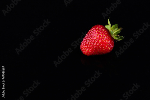 Fototapeta Naklejka Na Ścianę i Meble -  Red strawberries on a black background. Sweet life concept.