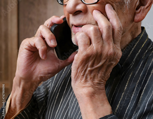 男性シニアがスマートフォンで電話をしている様子 photo