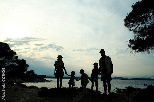 A happy family in nature by the sea on a trip silhouette