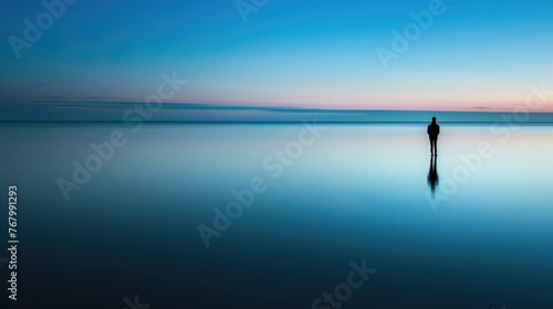 Person standing alone amidst expansive water, demonstrating solitude and isolation in a vast expanse