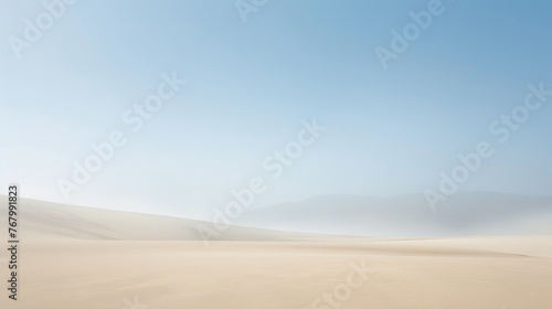A tranquil desert expanse enveloped in a soft haze under a clear sky photo
