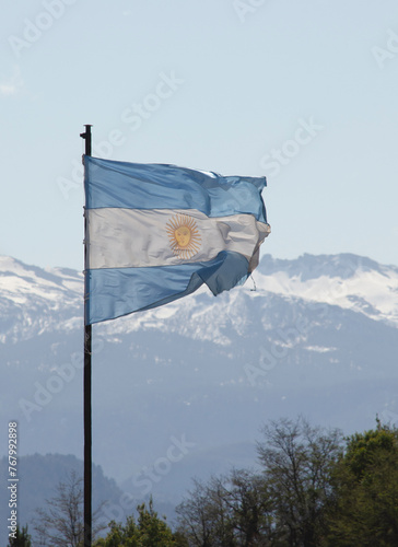 flag of the Argentine Republic worn fluttering with mountains and snow in the background. national symbol