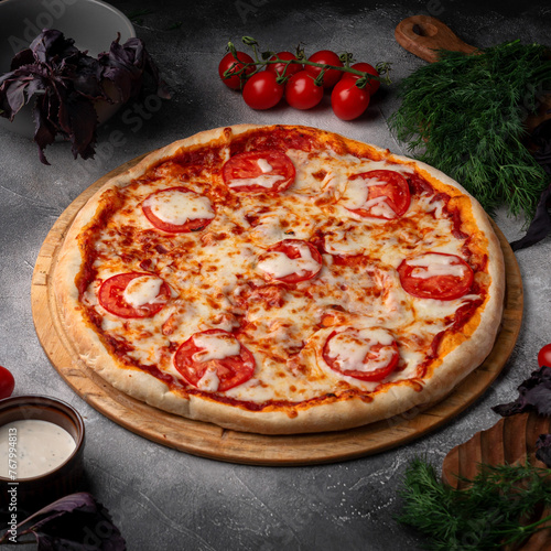 Tomato and cheese pizza with spiced tomatoes and cheese on a grey table