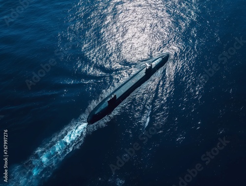 Aerial view of a submarine cutting through deep blue sea waters creating a wake.