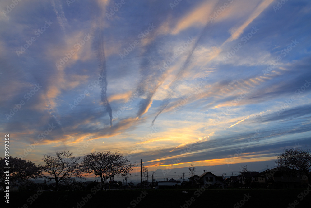 Obraz premium 夕暮れ時のたなびいた飛行機雲