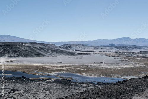 Un valle oscuro y pedregoso con una laguna azul.  © JanoGastn