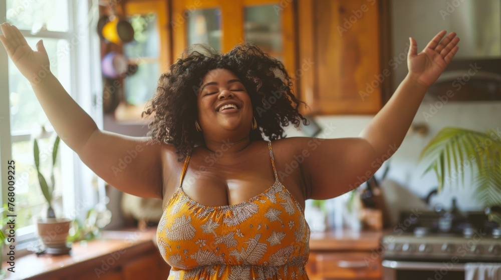 A African woman wearing a yellow dress is dancing in a kitchen - obrazy, fototapety, plakaty 