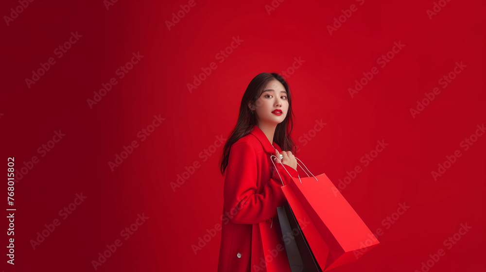 Beautiful Asian woman with shopping bags on red background with space for text. Black Friday sale Beautiful Asian woman with shopping bags on red background with space for text. Black Friday sale