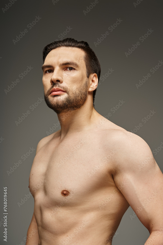 portrait of shirtless and handsome man with bristle and bare chest posing on grey background portrait of shirtless and handsome man with bristle and bare chest posing on grey background