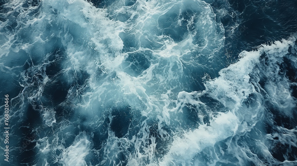 Aerial view of frothy ocean waves creating a dynamic and textured water surface.