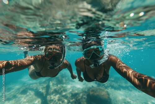 Two young women exploring the mesmerizing beauty of a vibrant coral reef while snorkeling in the crystal-clear waters of a tropical sea photo