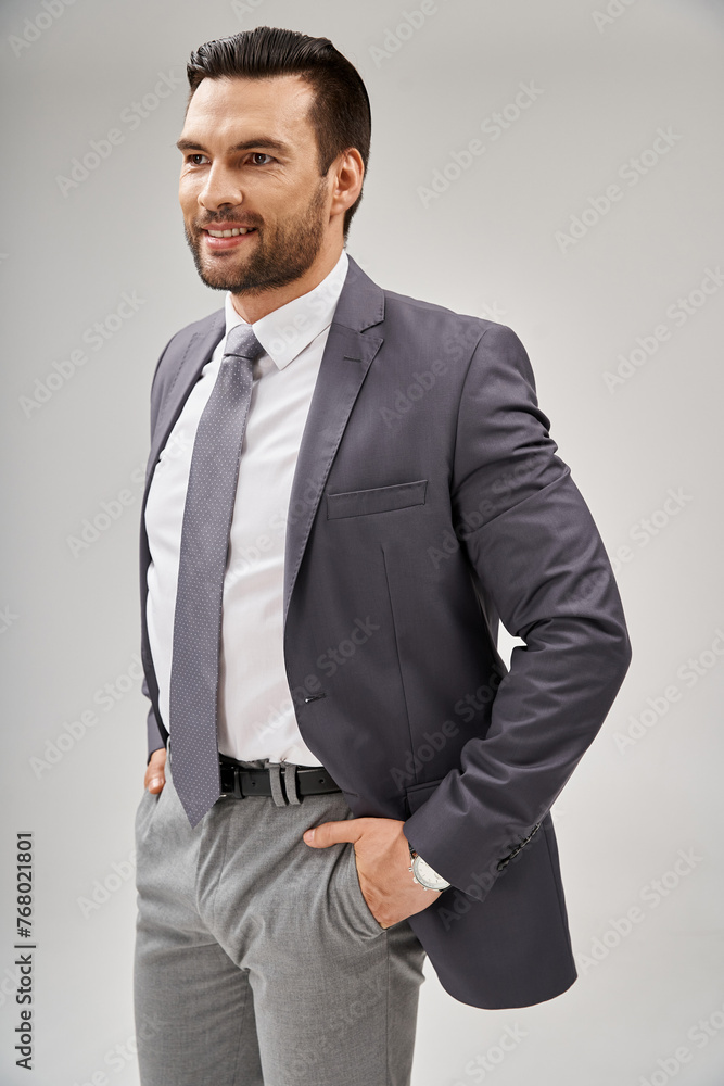 portrait of cheerful businessman in stylish attire posing with hands in pockets on grey background portrait of cheerful businessman in stylish attire posing with hands in pockets on grey background