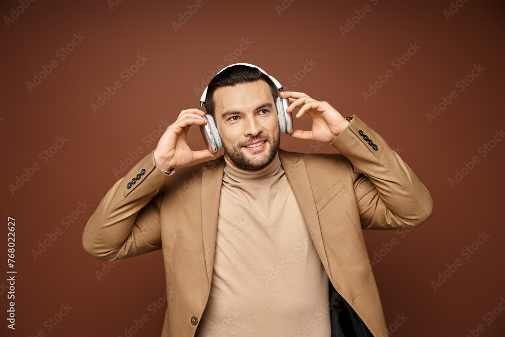 Charismatic man in elegant attire enjoying music in his wireless headphones on beige background Charismatic man in elegant attire enjoying music in his wireless headphones on beige background