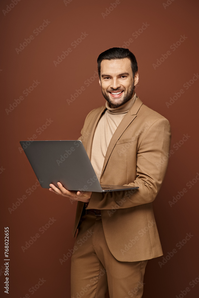 happy and handsome businessman holding his laptop while working remotely on beige background happy and handsome businessman holding his laptop while working remotely on beige background
