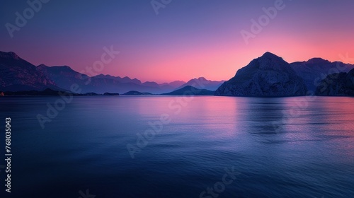 Twilight hues over serene mountains and dark shorelines photo