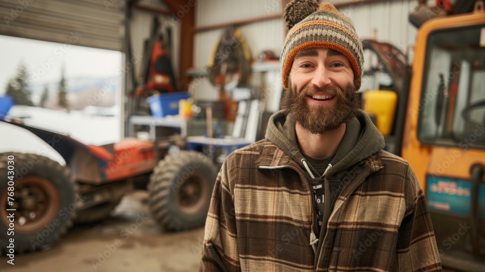 A cheerful and kind technician, wearing a beanie, hoodie, and beard, in a winter workshop. A cheerful and kind technician, wearing a beanie, hoodie, and beard, in a winter workshop.