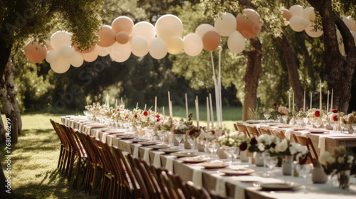 Wedding table decorated with balloons and flowers in the park .