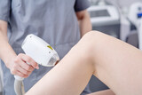 Professional beautician removes hair on beautiful female legs using a laser. hair removal on the legs, laser procedure at clinic