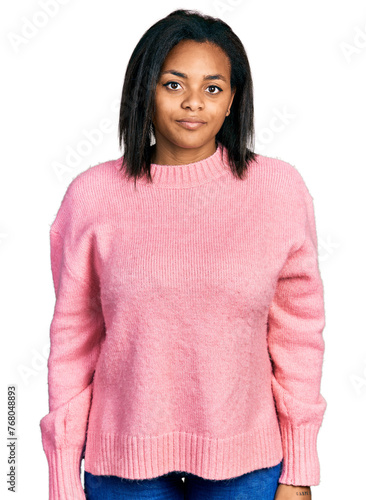 Beautiful hispanic woman wearing casual winter sweater relaxed with serious expression on face. simple and natural looking at the camera.