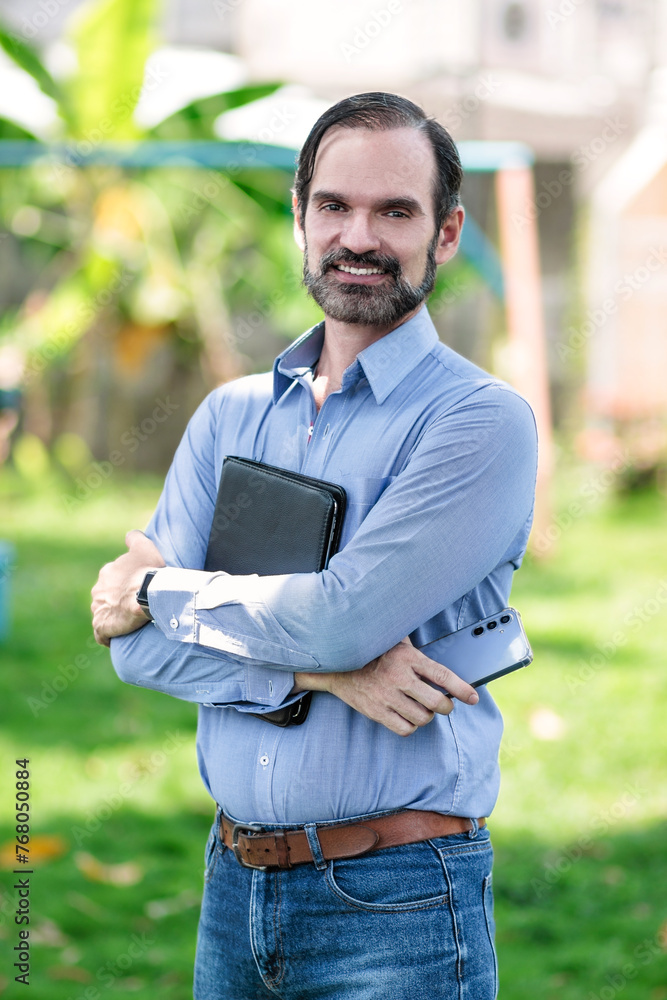 Hombre de negocios adulto latino con tableta y celular para estar comunicado con el trabajo en el parque Hombre de negocios adulto latino con tableta y celular para estar comunicado con el trabajo en el parque
