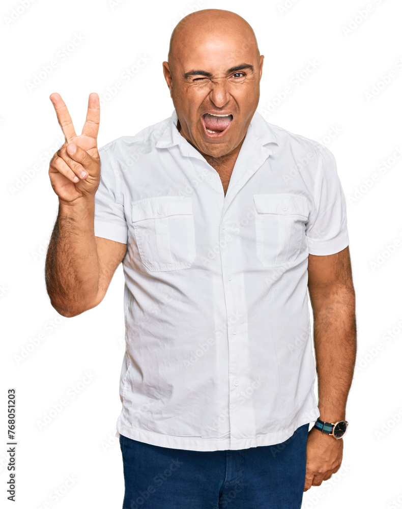 Mature middle east man with mustache wearing casual white shirt smiling with happy face winking at the camera doing victory sign with fingers. number two.